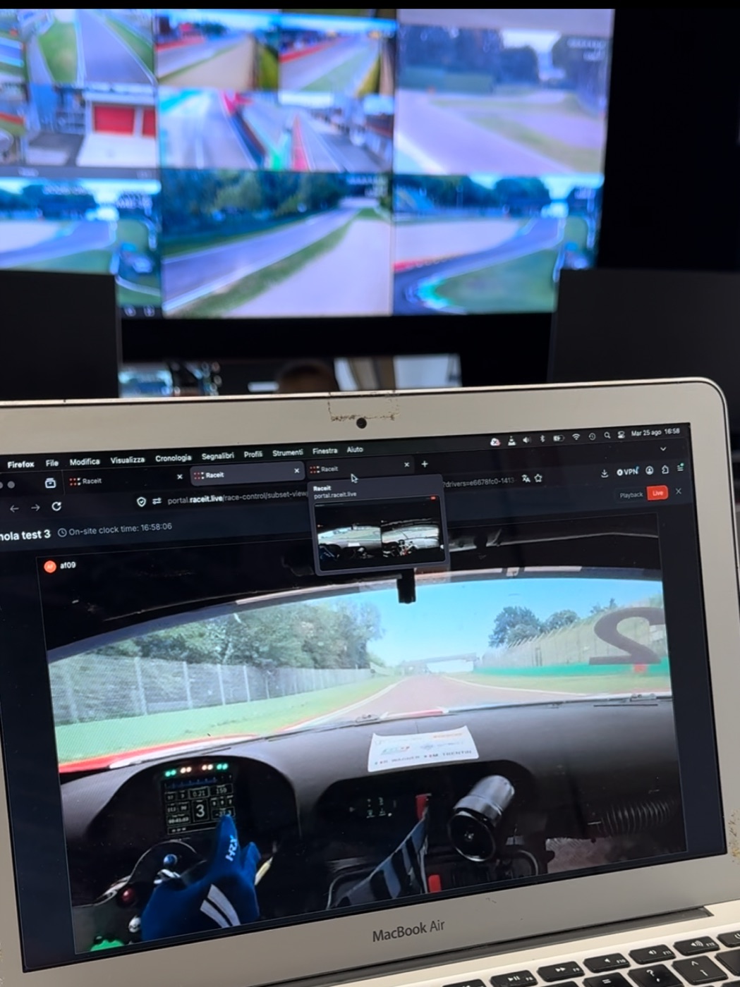 RaceIT Race Control on a laptop in front of the circuit monitor wall